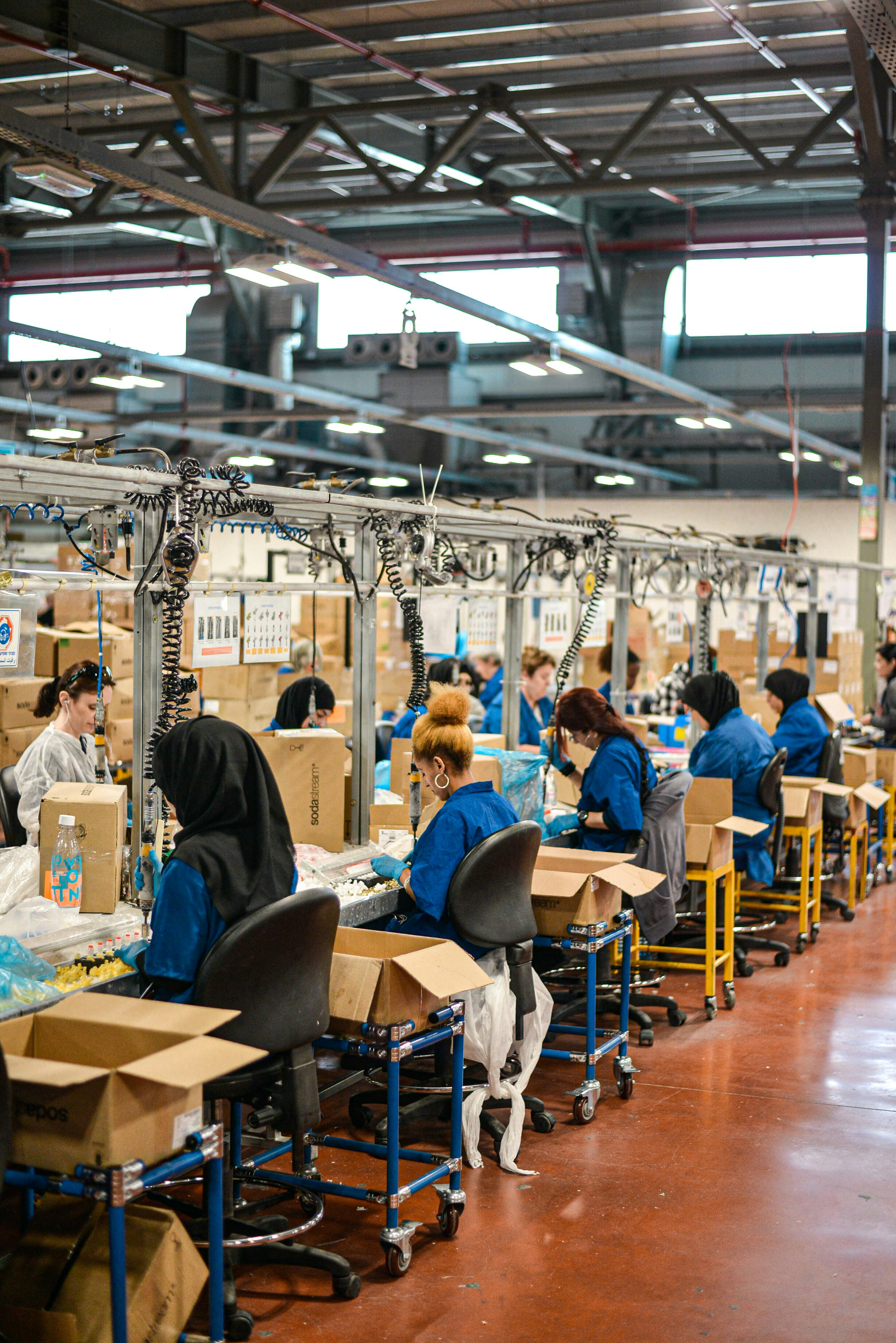 People sitting in a row working in a factory.
