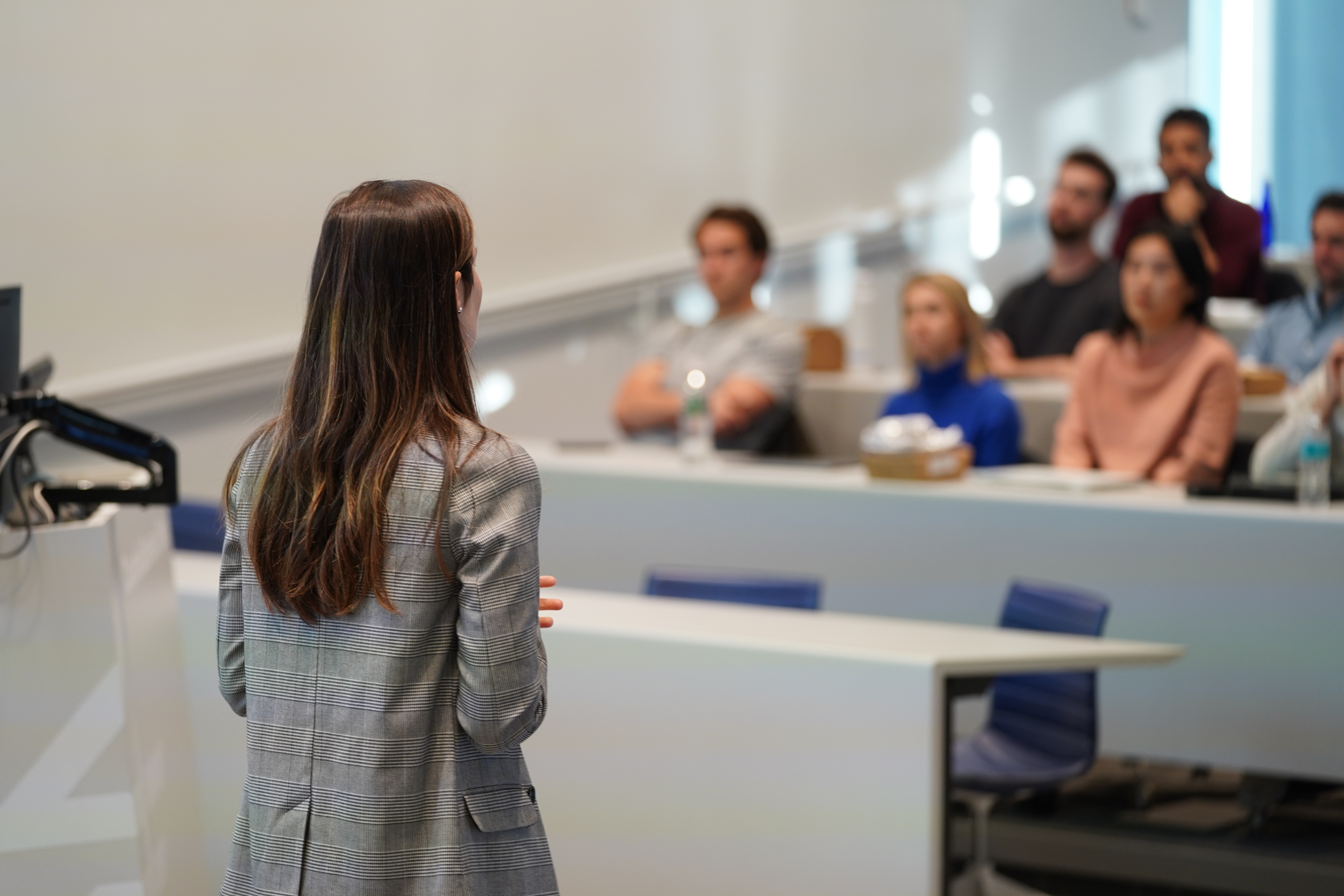 A professor stands in front of a classroom, practicing lecturing