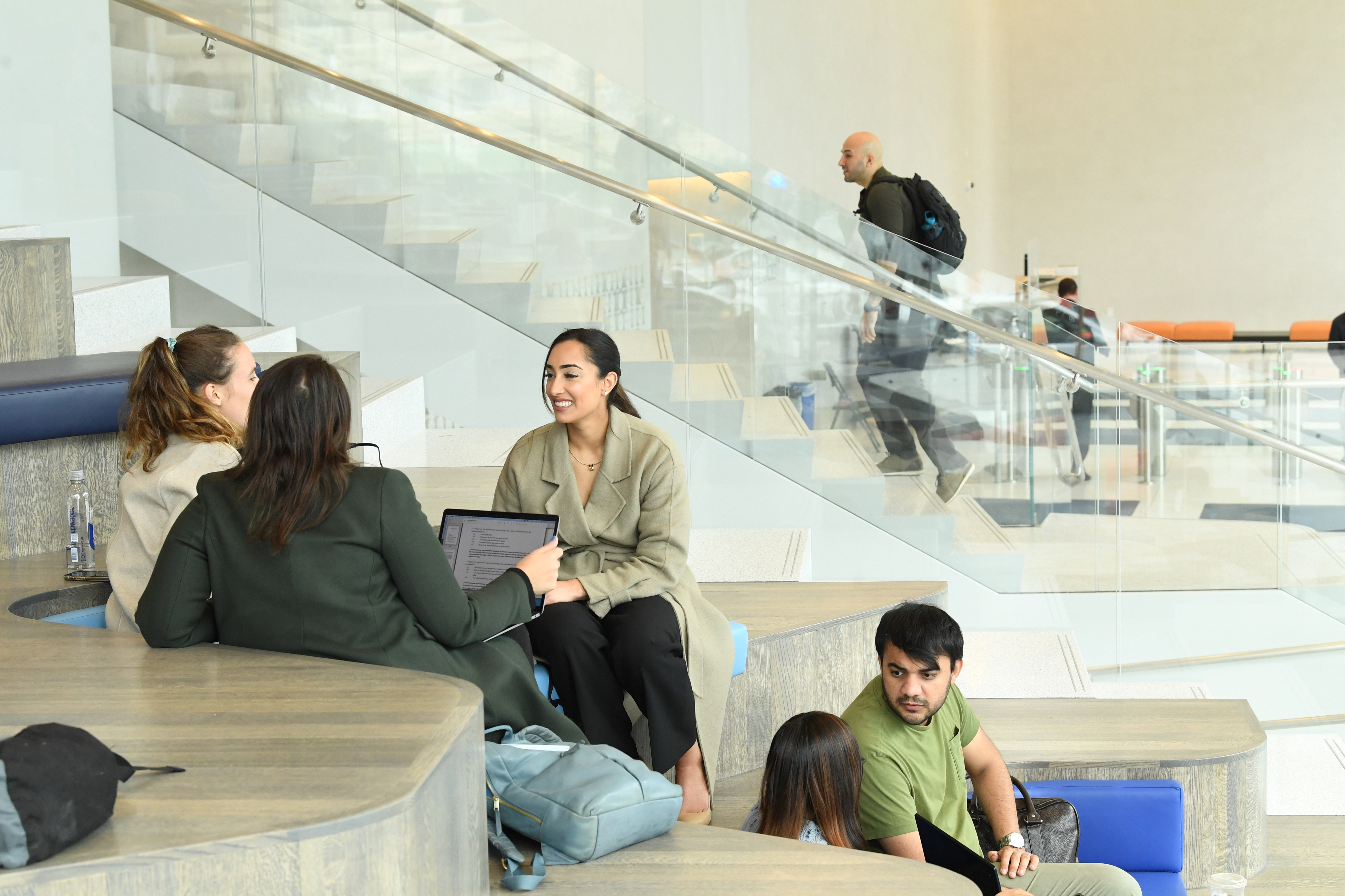 Students sitting and talking in the lounge area of Kravis Hall
