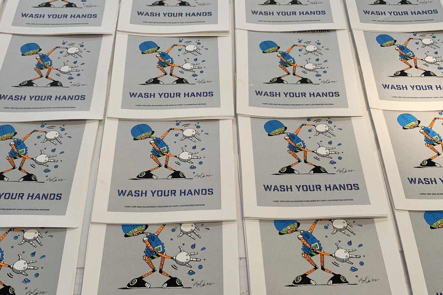 Stacks of pamphlets with a cartoon charcter, that says wash your hands.