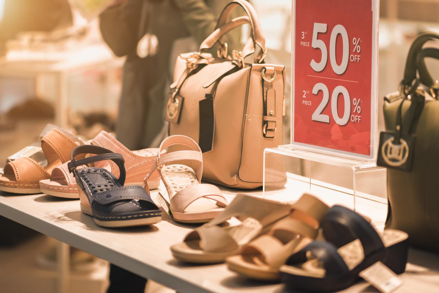 A retail sales display with women's shoes and purses.