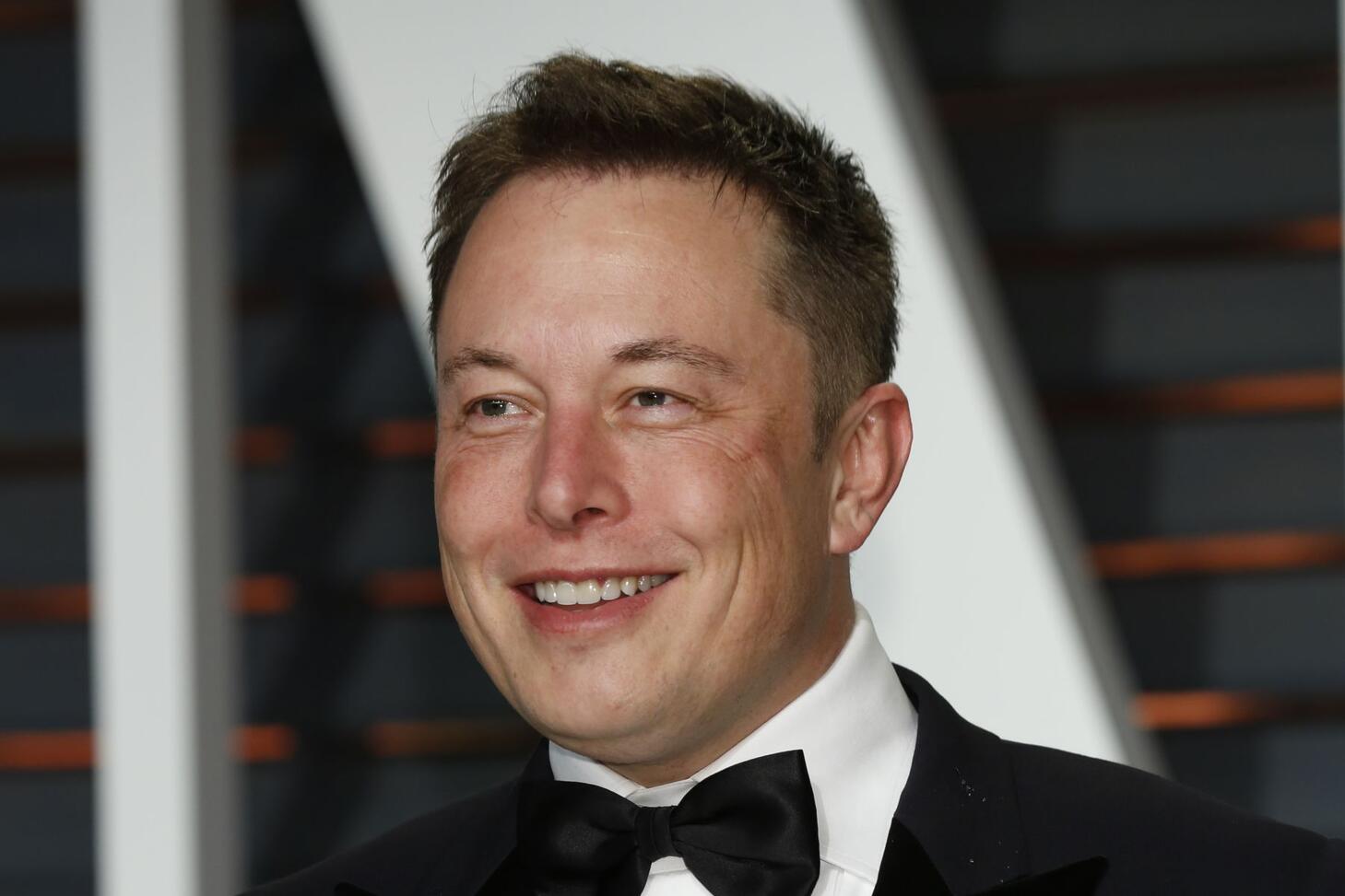 Elon Musk in a tuxedo, grinning