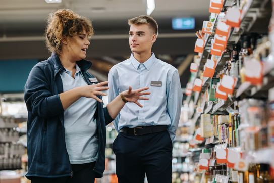 A manager trains a store employee