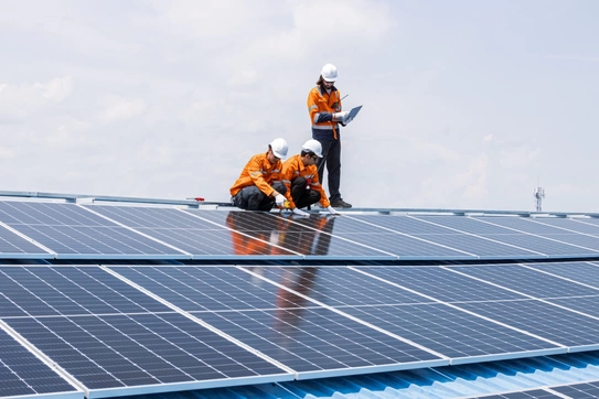 Maintenance workers service a solar panel.