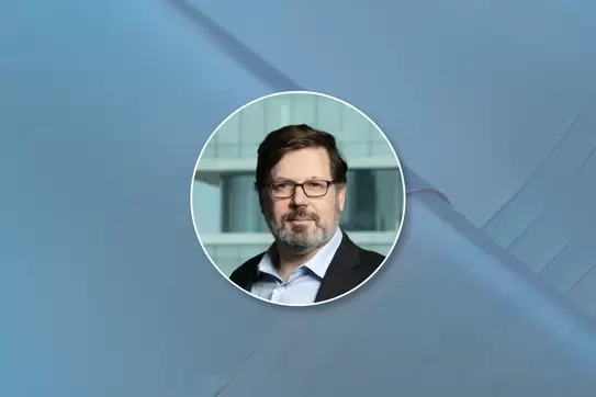 Headshot of Daniel Wolfenzon on a blue background 