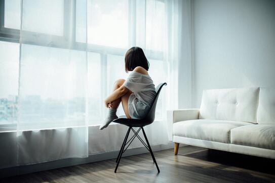 Woman sitting on black chair in front of glass-panel window with white curtains photo. Photo by Anthony Tran on Unsplash.