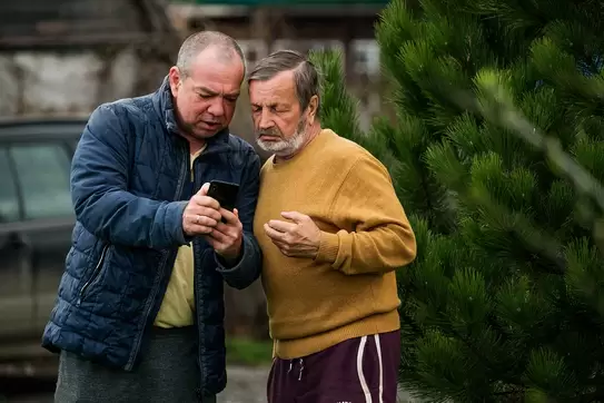 Two men discussing bad news, looking at the screen of a smartphone