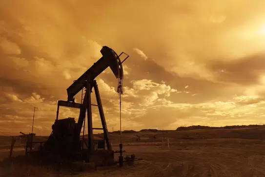 An out-of-service oil derrick in the sunset