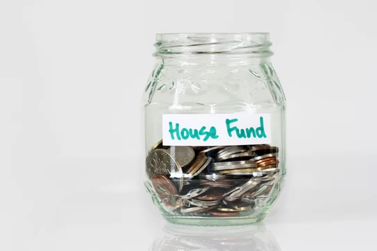 Jar labeled "house fund" with coins in it