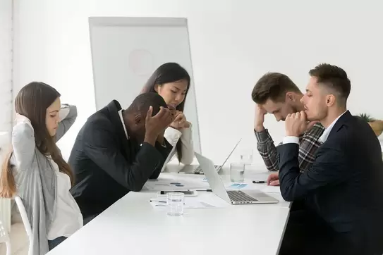 Stressed multiracial team at office meeting.