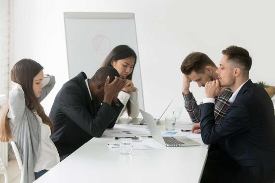 Stressed multiracial team at office meeting.