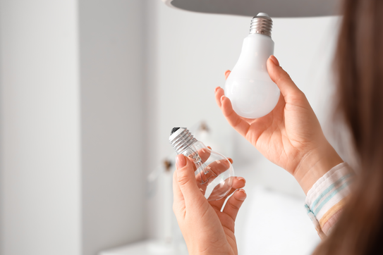 A person switching light bulbs
