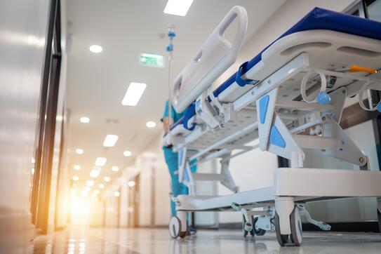 An image of a hospital with a bed in the foreground