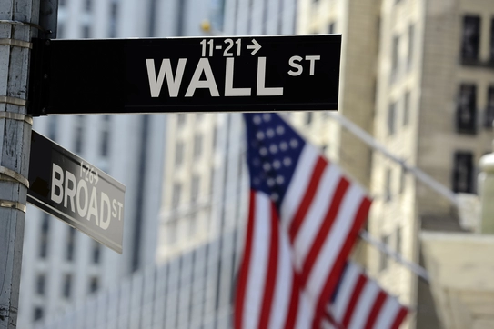 A Wall Street sign and an American flag