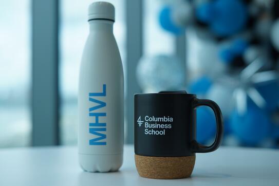 A CBS-branded water bottle and mug sit next to each other on a table