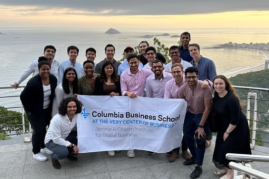 Students in front of ocean with Chazen banner