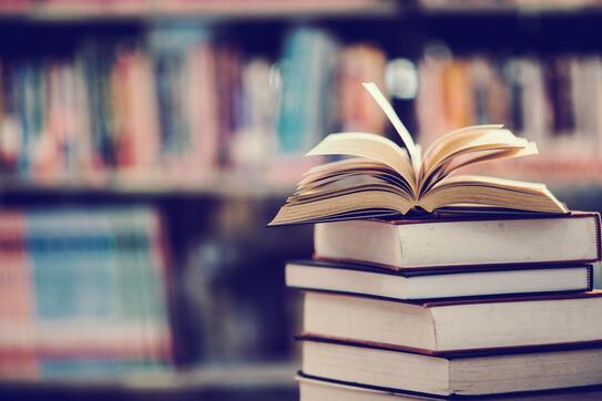 An open book on top of stacked books