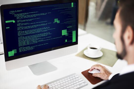 Someone sits in front of a computer, working