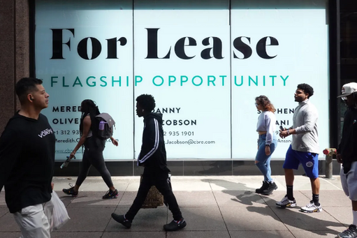 people walking by a "for lease" sign