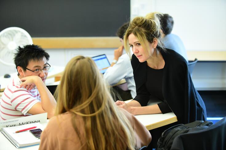 A professor listens to two students