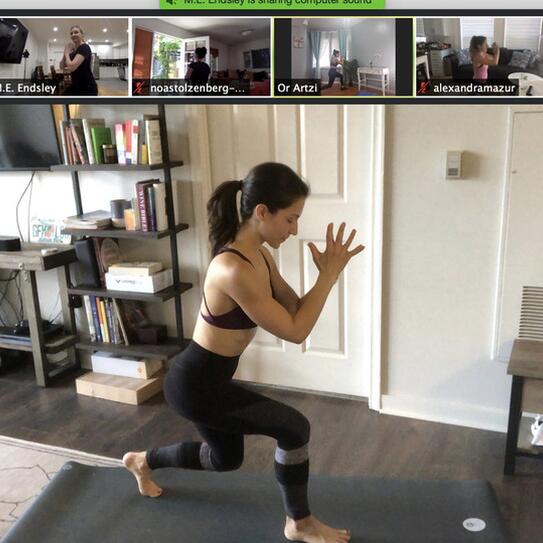 Woman demonstrating pilates moves onscreen 