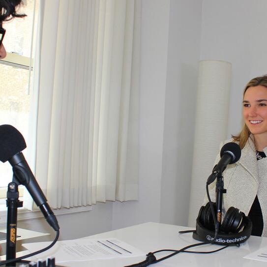 Clare Murphy and Fahad Ahmed sitting at two microphones