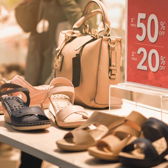 A retail sales display with women's shoes and purses.